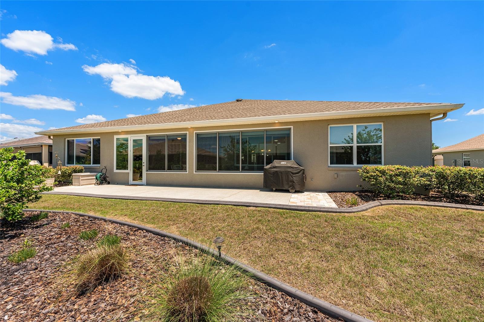 Beautifully landscaped backyard featuring a spacious 38' x 10' patio, soffit lighting, and a dedicated gas line for the included barbecue grill. An ideal setting for outdoor entertaining and relaxation.