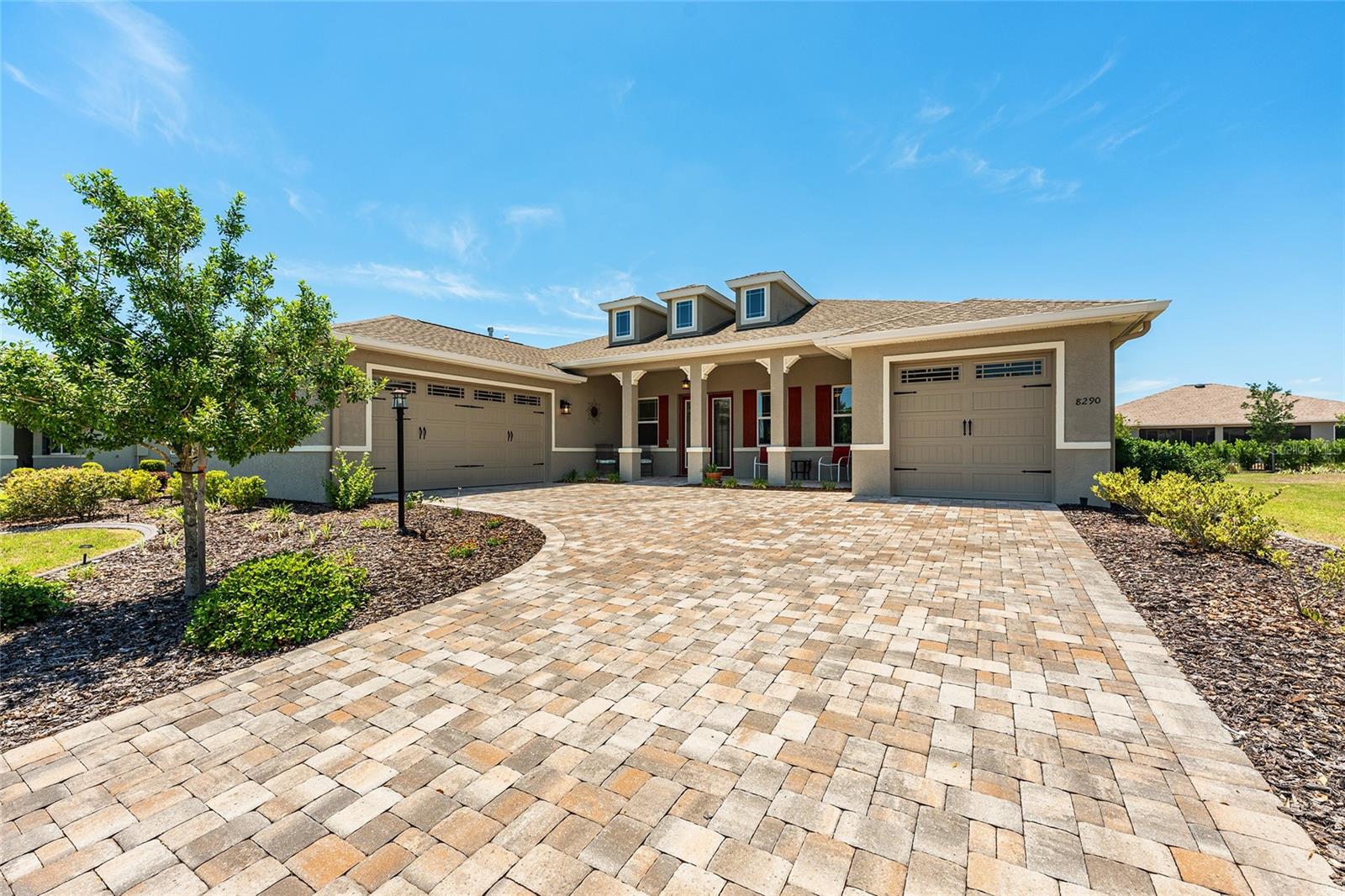 Beautiful 2021 Aberdeen model in West Kestrel at Candler Hills, showcasing exceptional curb appeal with an expansive paver driveway, inviting covered front porch, distinctive architectural details, and a desirable split three-car garage. Professionally landscaped grounds feature Zoysia grass, decorative concrete curbing, full-yard irrigation with Hunter Hydrawise controls, and gutters with downspouts.