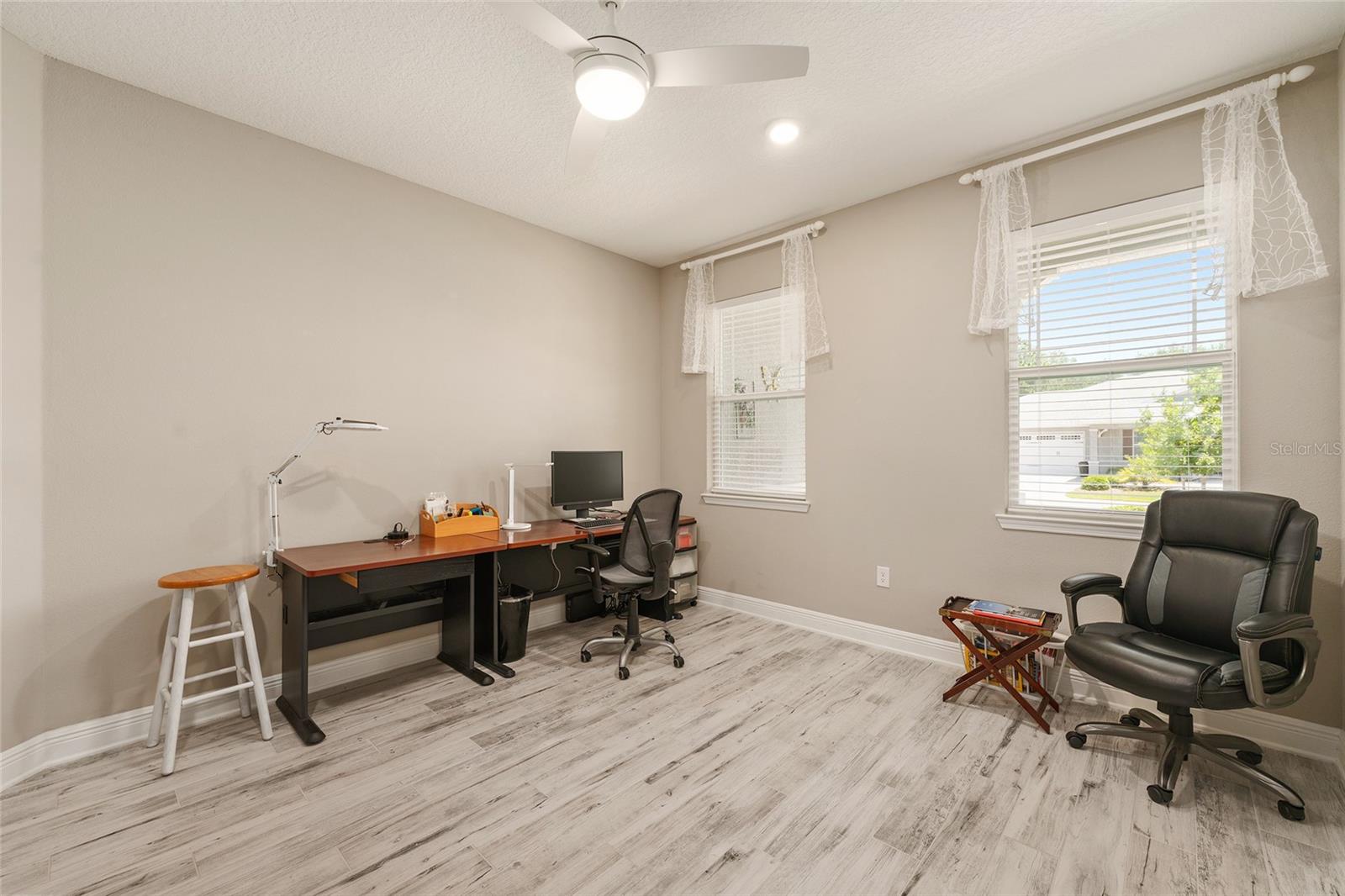Two front-facing windows fill this spacious flex room with natural light, offering a bright and comfortable setting for a home office, reading lounge, or creative workspace.
