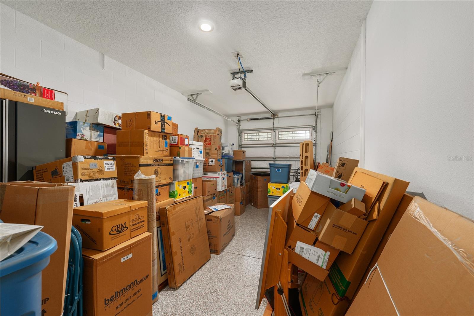 Extra-deep third-car garage featuring epoxy flooring, recessed lighting, and a dedicated golf-cart electrical outlet. Ideal for golf cart parking, an additional vehicle, or generous storage space.