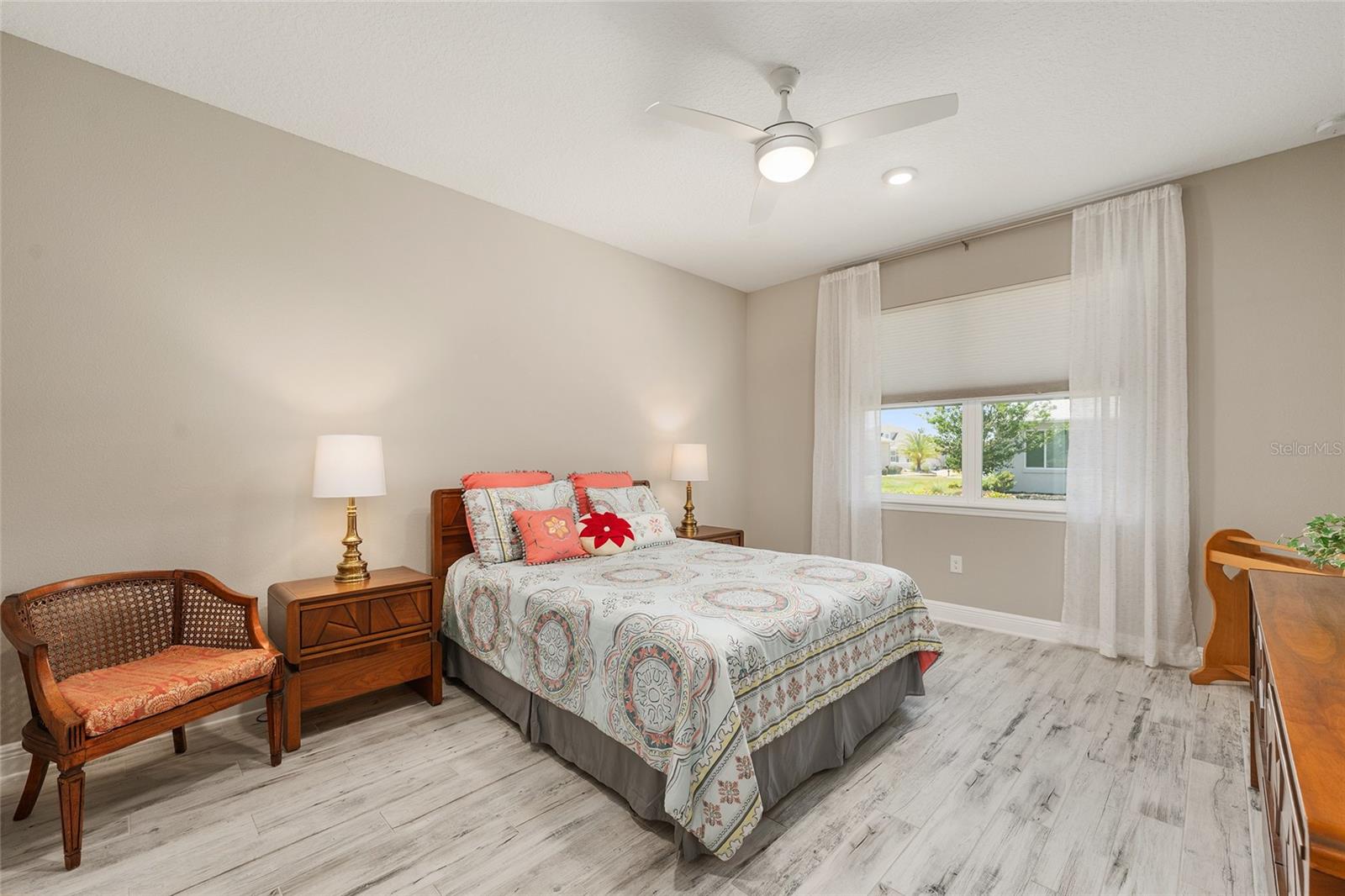 Spacious second primary suite featuring ceramic plank flooring, a ceiling fan with integrated lighting, and a large window that welcomes natural light. Complete with a private ensuite bathroom, this inviting retreat offers comfort and privacy for extended guests or multigenerational living.