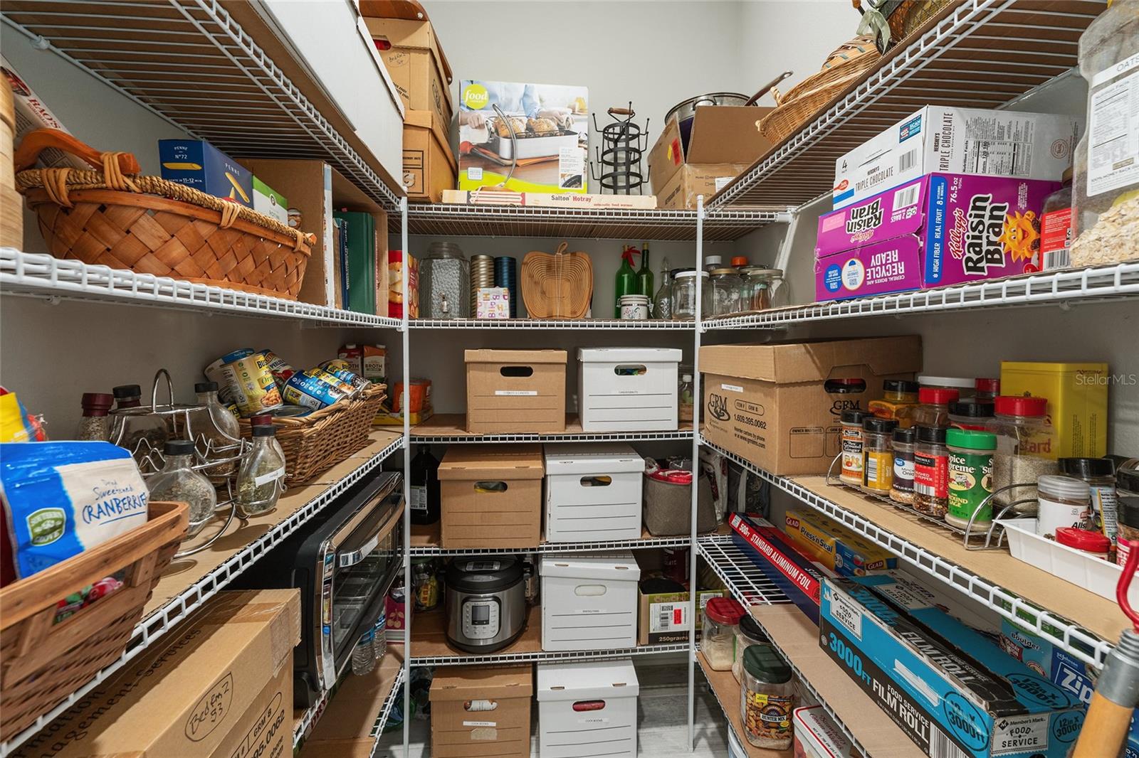 Spacious walk-in pantry conveniently located off the kitchen near the two-car garage for easy grocery unloading, featuring abundant shelving and generous storage space for food, small appliances, and household essentials.