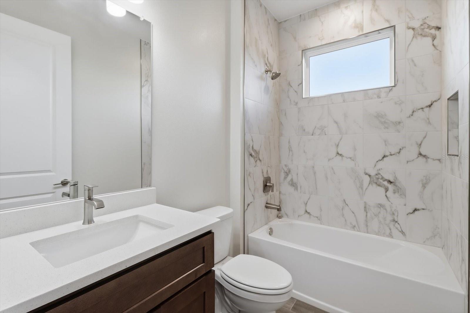 Bathroom 2 with a tile shower and tub.