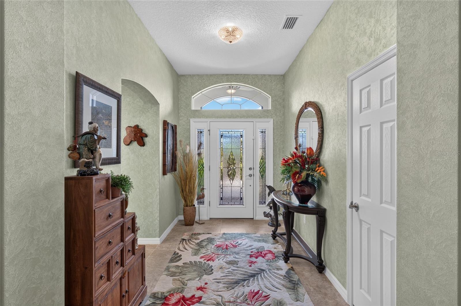 LEADED GLASS FRONT DOOR WITH DOUBLE SIDE LIGHTS AND TRANSOM WINDOWS.