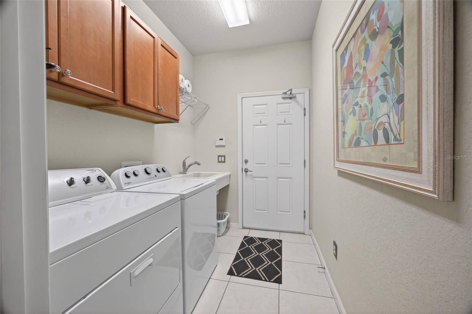 Laundry room with storage cabinets. 2 car garage.