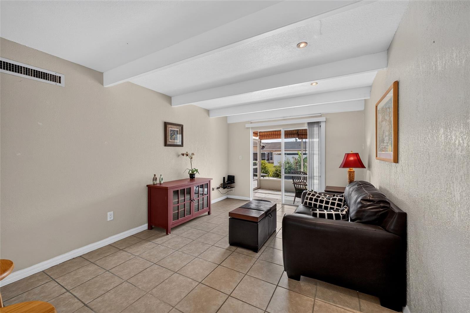 Sliding glass door at the end of the living room allows natural light to filter inside the home.