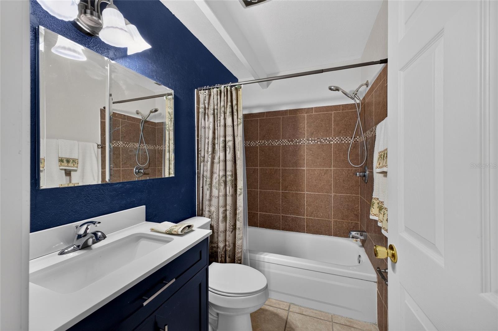 The bathroom has a new cabinet/sink/faucet/toilet and tile.