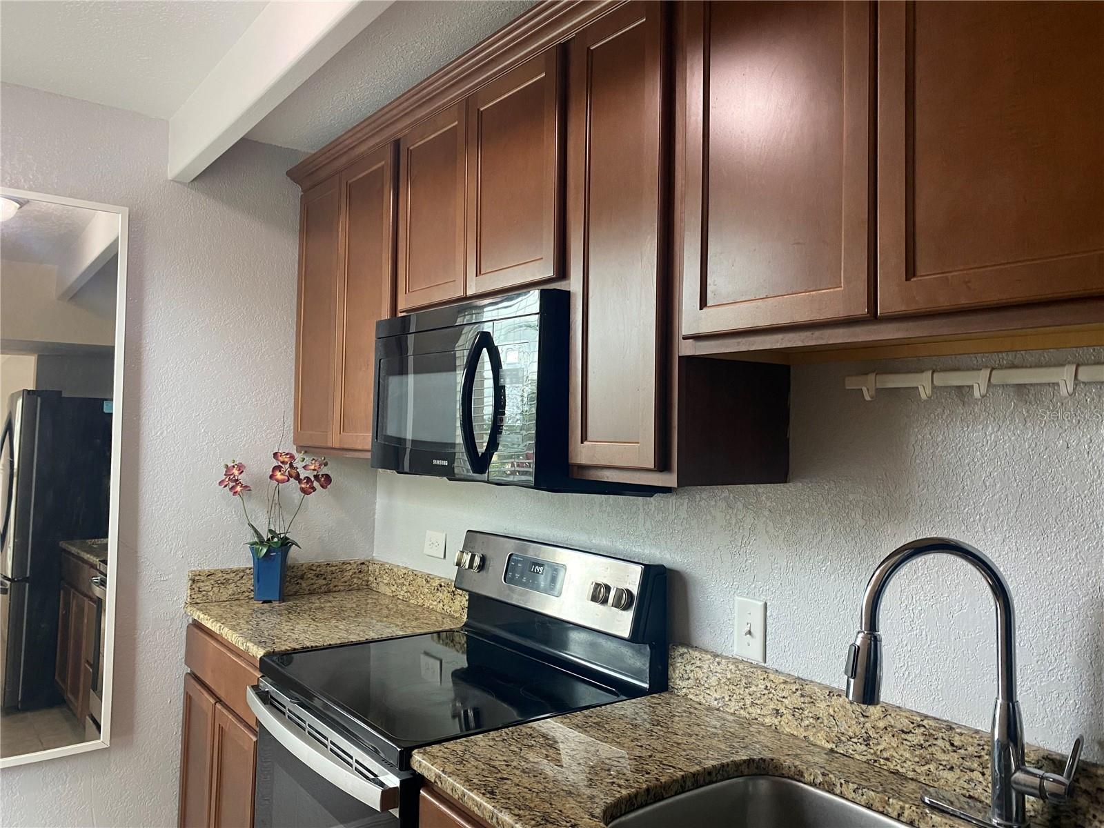 The galley kitchen has beautiful wood cabinetry.
