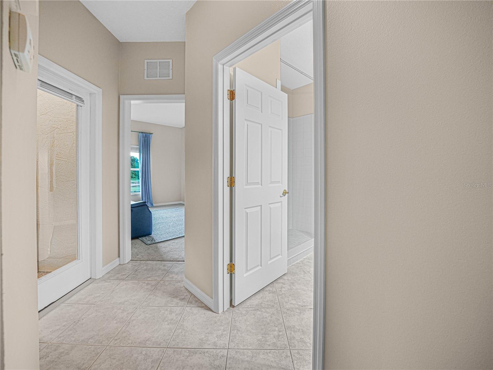 Tiled Hallway to the Guest Bath, Bed 3 and Covered Florida Room