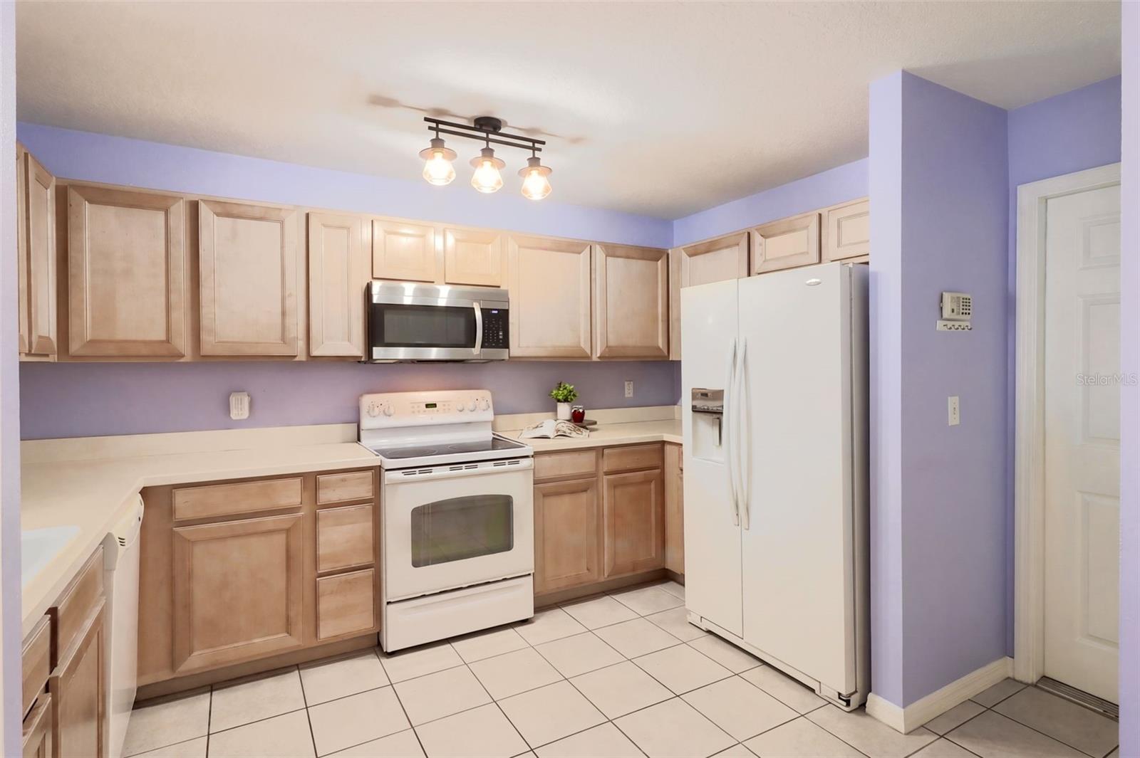 The kitchen features maple wood cabinetry, an updated microwave