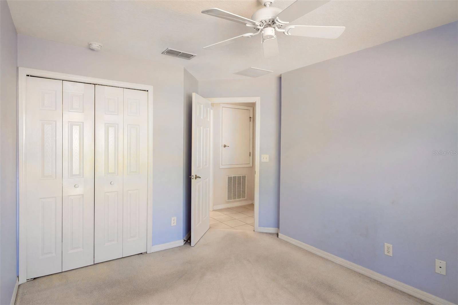 Guest bedroom features a ceiling fan