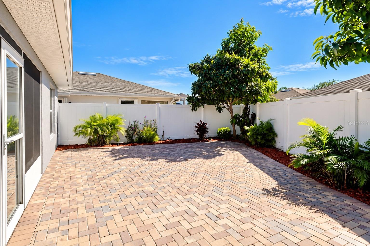 Low-maintenance courtyard, enhanced with pavers and Florida-friendly landscaping, provides a private and inviting outdoor retreat.