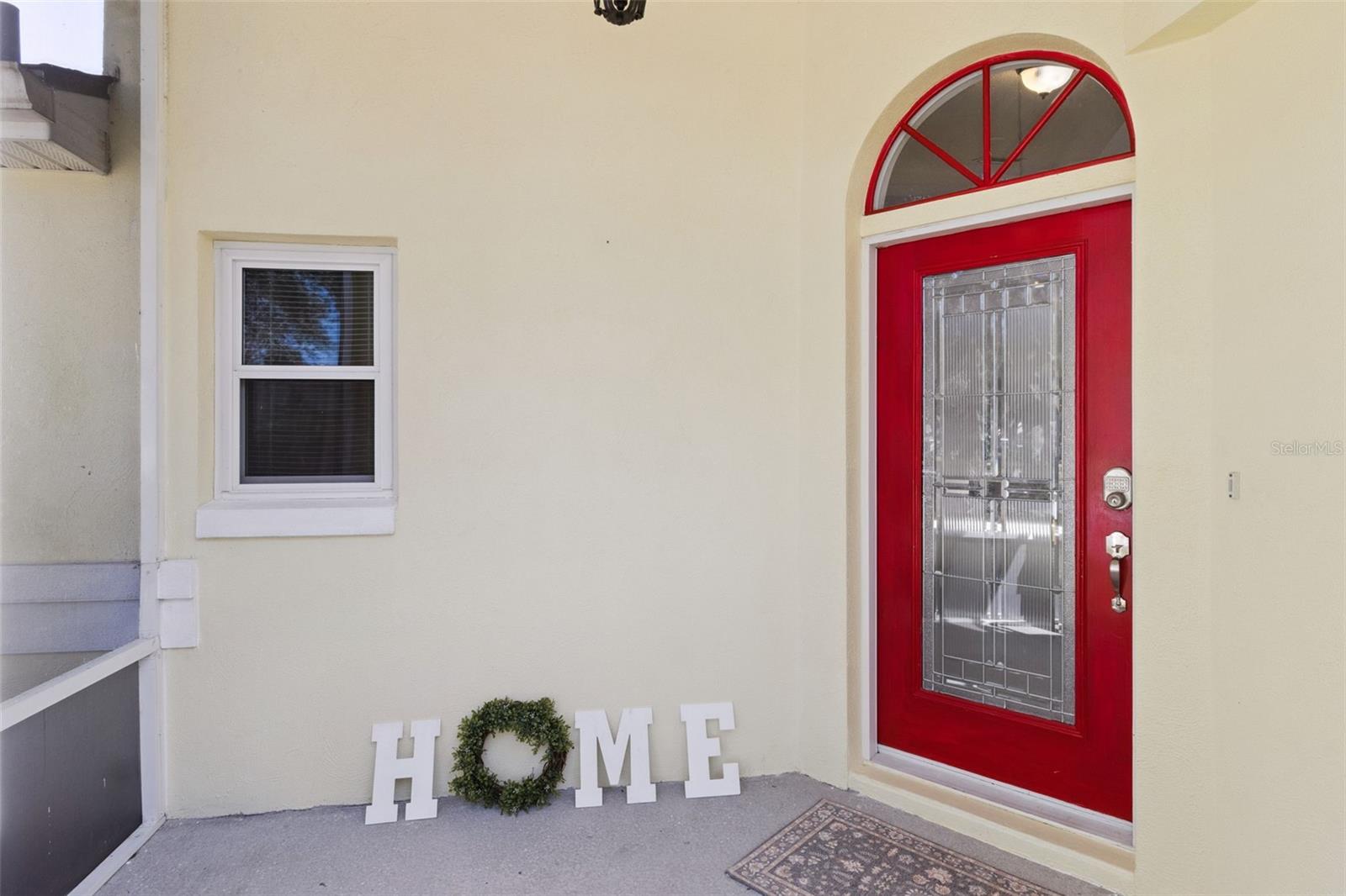 Screened-in Front Entry adorned with a Leaded Glass Front Door and Transom Window