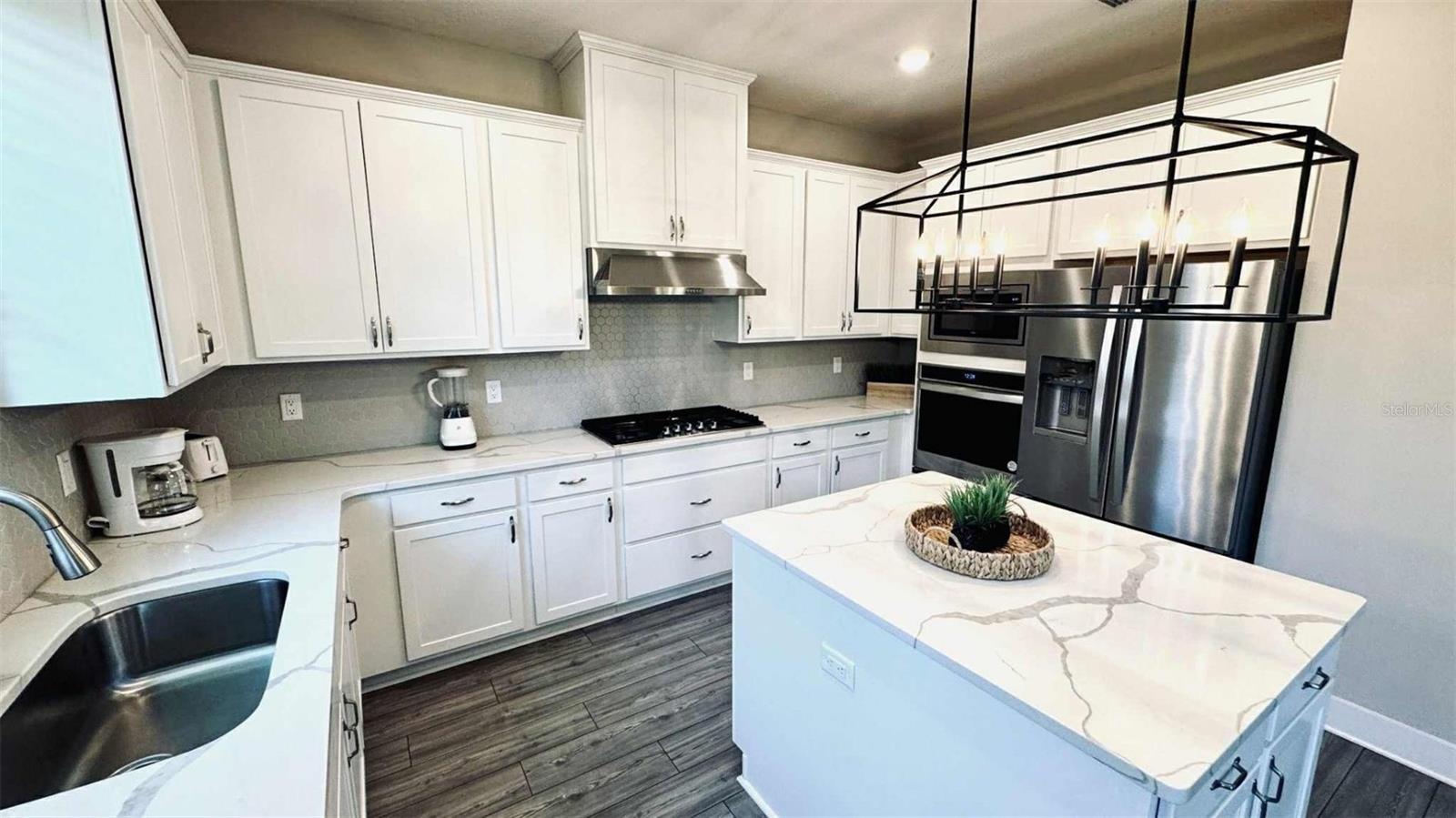 Modern kitchen with granite countertops, stainless-steel appliances, and large island ideal for gatherings.