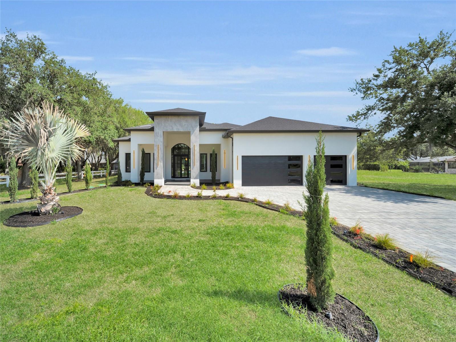 Front elevation with landscaped curb appeal and paver driveway Front elevation with landscaped curb appeal and paver driveway