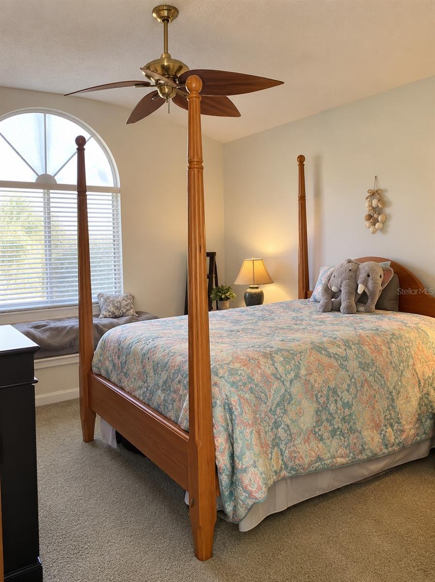 Primary bedroom with sitting area, ceiling fan and volume ceilings