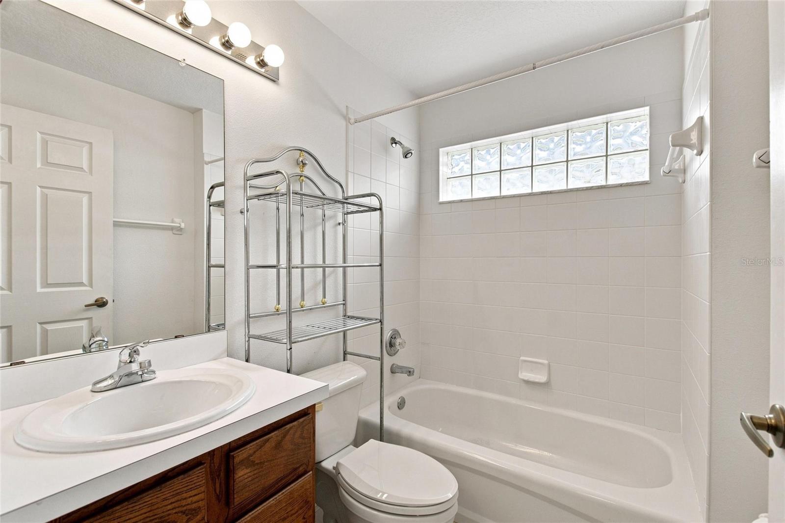 Guest bathroom has linen closet in hallway