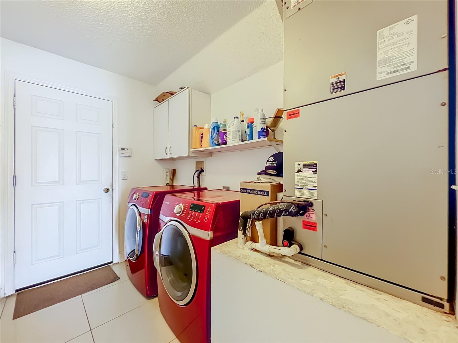 Off the kitchen is the 1st floor inside laundry room with nice Samsung washer and dryer, storage cabinets and storage shelf. Leading to the attached garage.