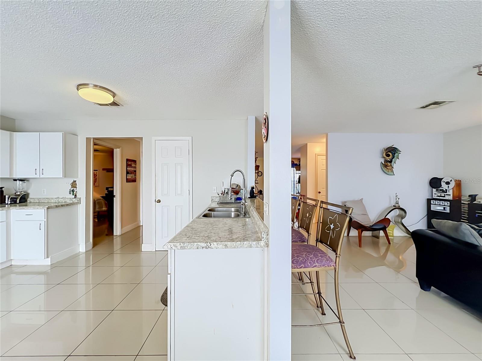 Kitchen and Family room show hallways to Primary bedroom on the left and to the 1/2 bath leading to front of the house
