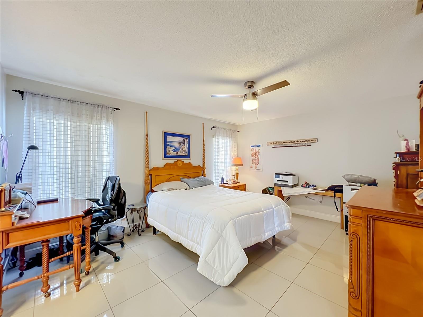 Primary bedroom on 1st floor with ceiling fan and ceramic tile floor