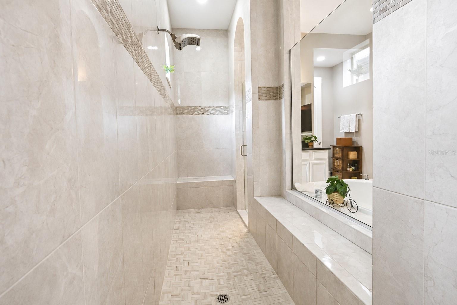 Oversized Shower with multiple rain heads, bench, and niche