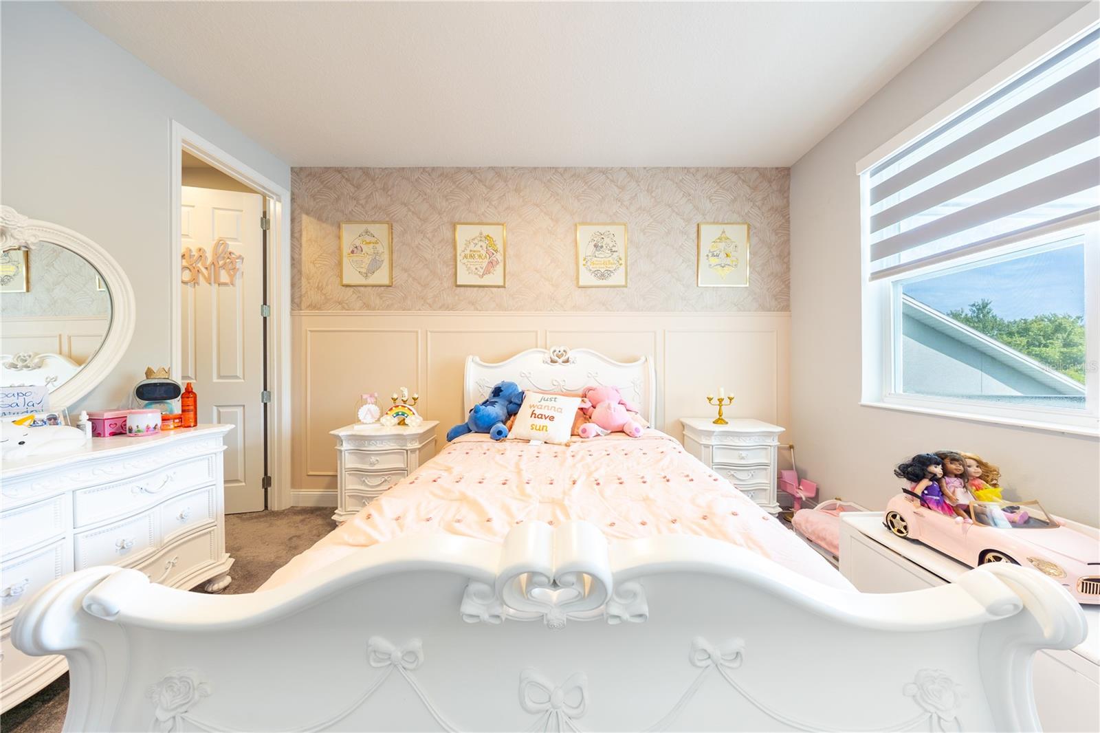 Charming bedroom with decorative wall paneling, patterned wallpaper, and a large window.
