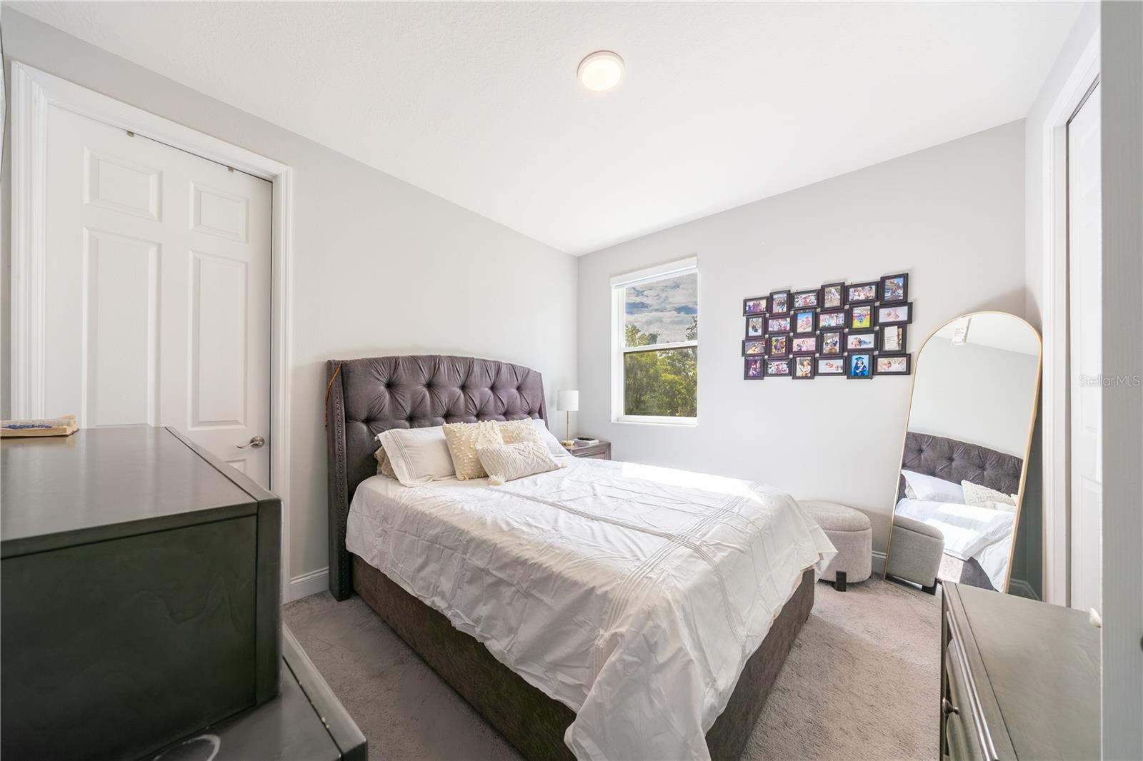 Inviting bedroom with soft carpeting, neutral tones, and a double-door closet.
