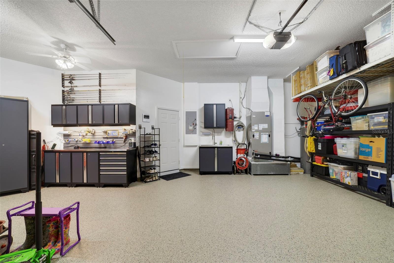 Another view of this magnificent garage space with custom workshop and storage shelves