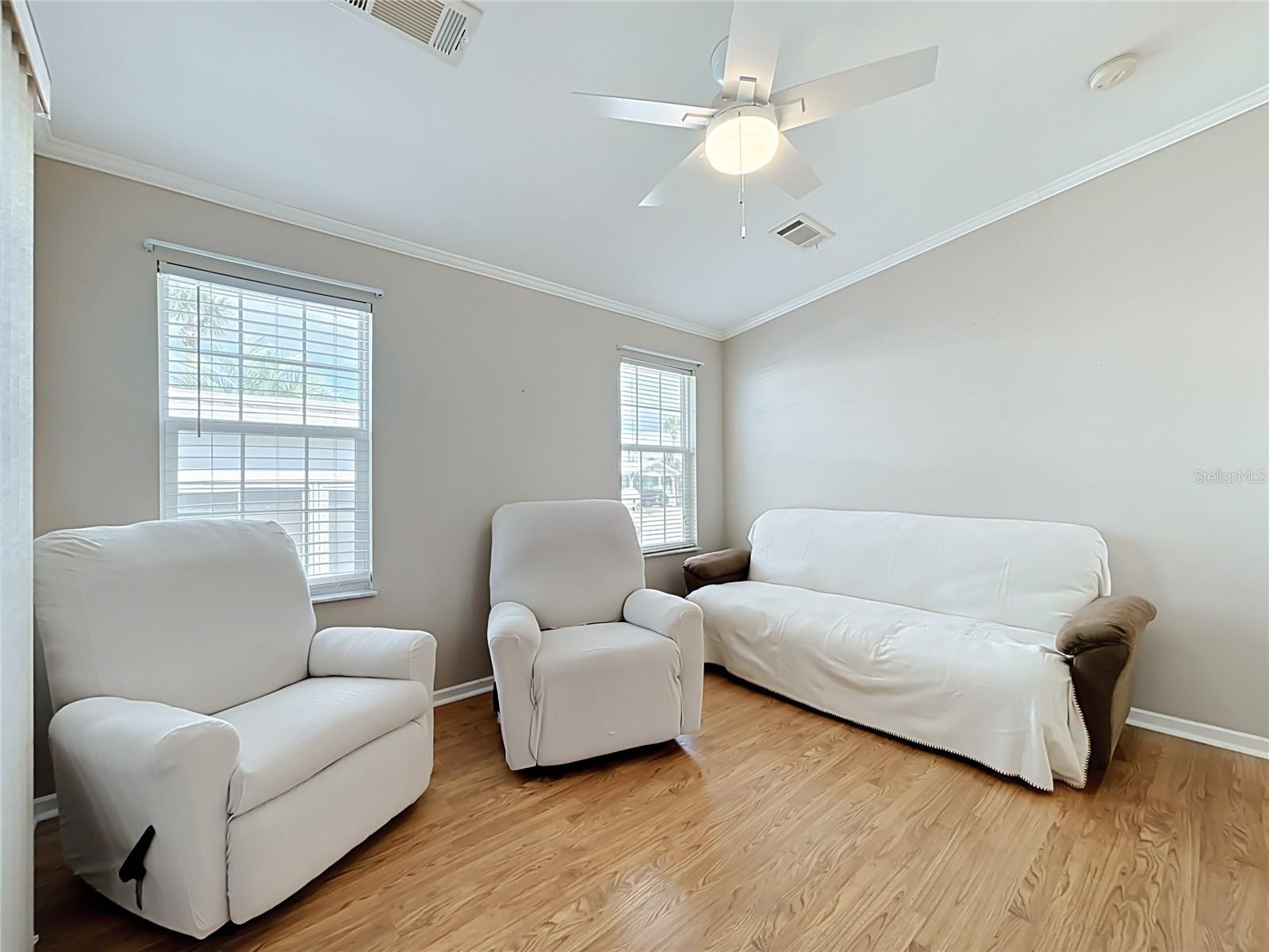 Living room provides easy access to elevated screen room with vinyl windows overlooking and providing access to the rear deck