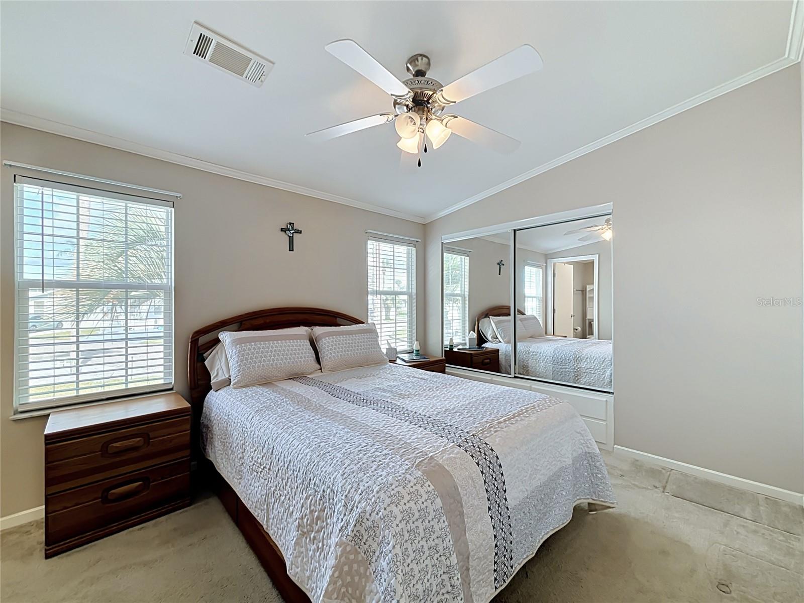 Well proportioned primary bedroom benefits from built in closets and drawers