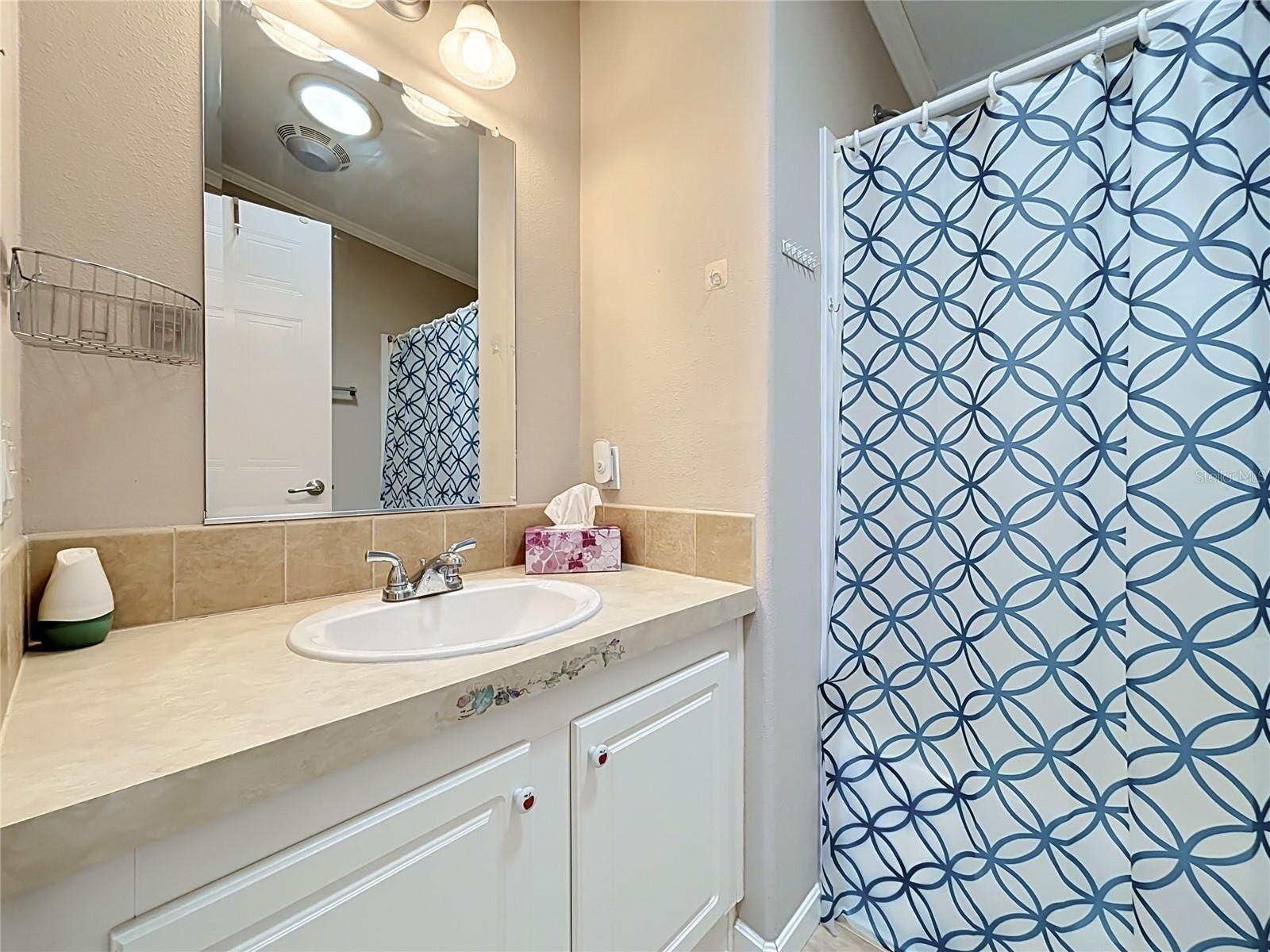 Guest bathroom sits conveniently in the hallway between the dining area and bedrooms