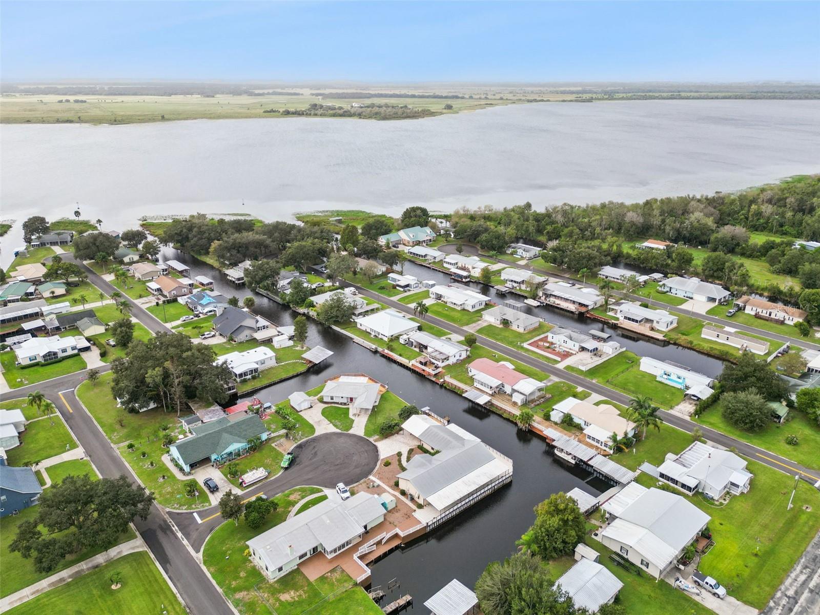 Aerial Location Overview: Wide neighborhood drone perspective highlighting the home's premier position on the canal.