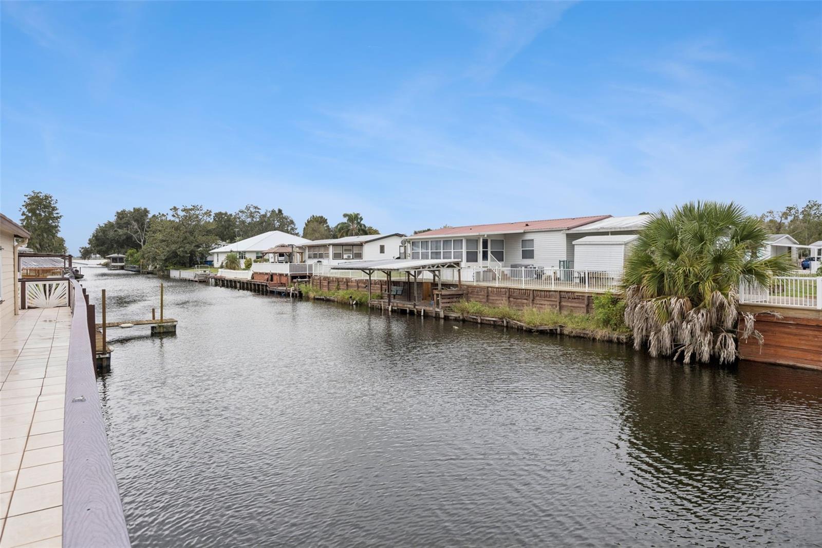 Direct Canal Access: Clear view down the canal waterway highlighting easy boat access and neighboring docks.