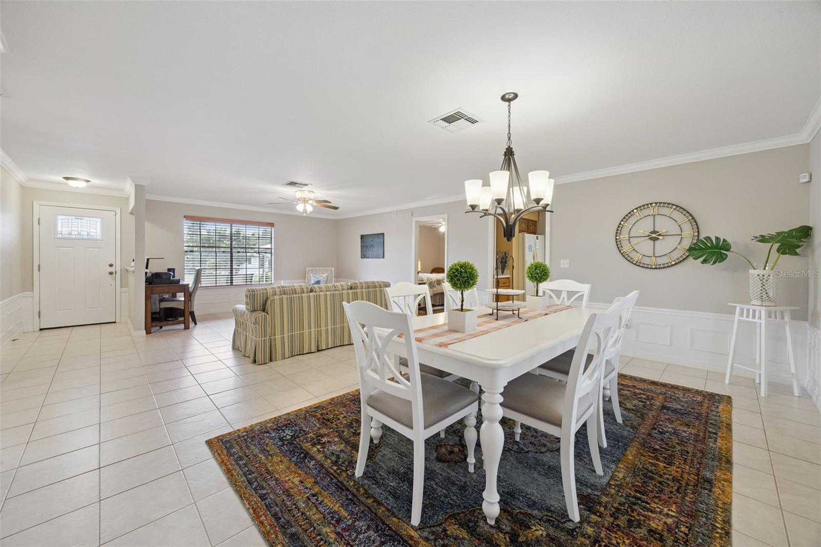 Open Living & Dining Area: Generous open-concept living space linking the main entry, formal dining area, and living room with easy-maintenance ceramic tile throughout.