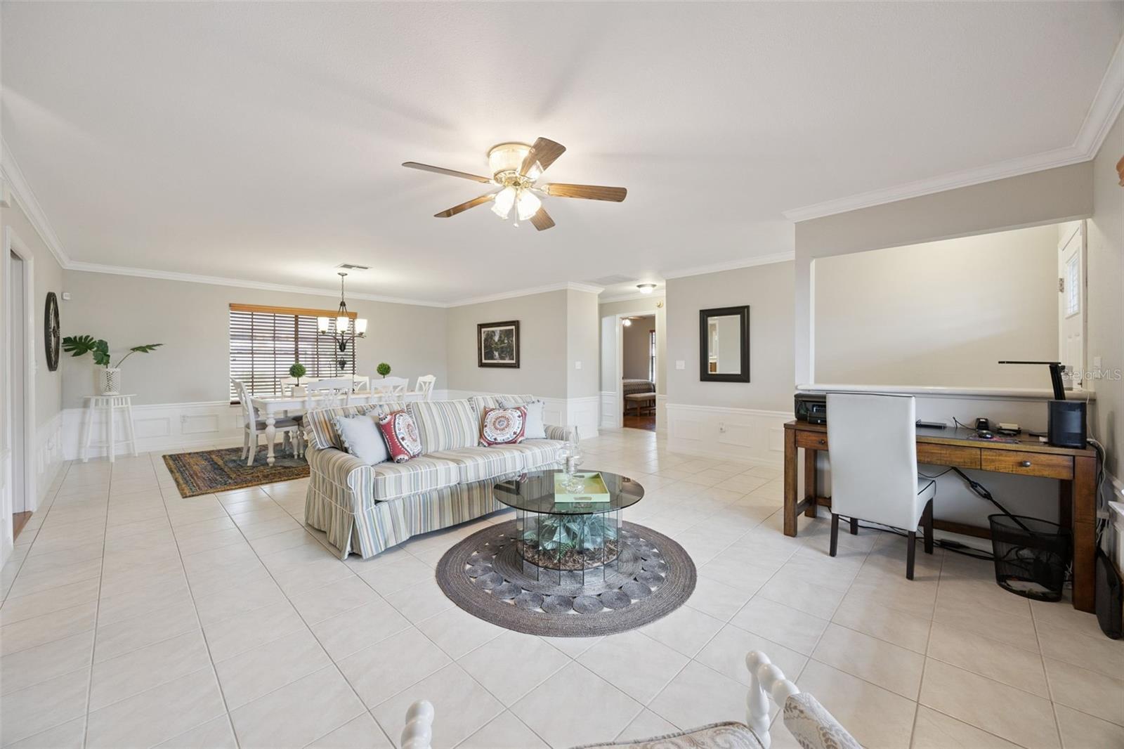 Great Room & Home Office Nook: Versatile main living area featuring neutral wall tones, tile floors, formal dining area, and a dedicated desk workspace nook.