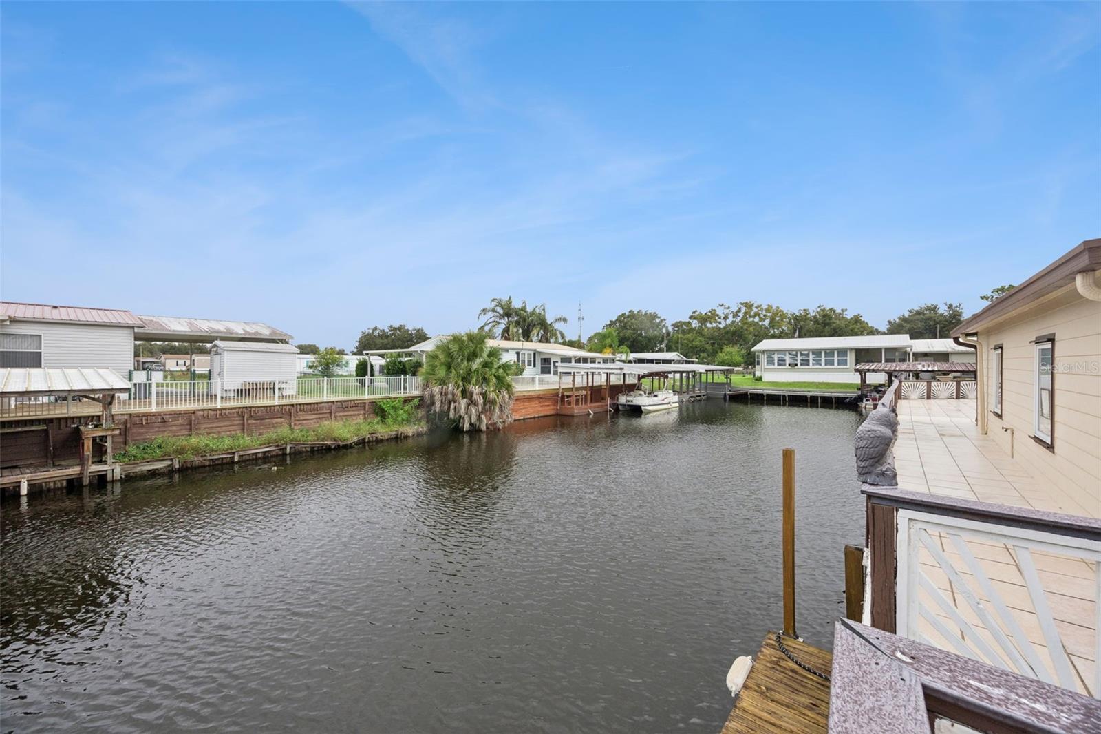 Private Boat Dock Overview: View of the private wooden boat dock and mooring area directly behind the residence.