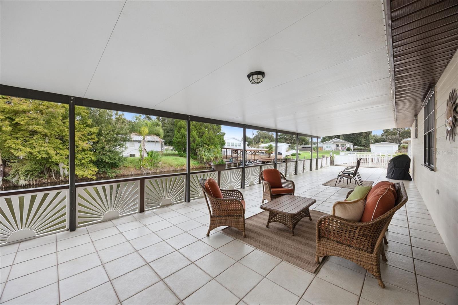 Covered Outdoor Living Area: Spacious covered back porch providing ample room for outdoor dining, lounge seating, and waterfront relaxation