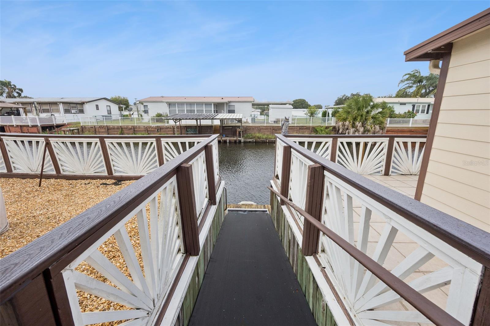 Ramp Access to Boat Dock: Secure ramp leading down from the tiled patio deck to the private boat dock