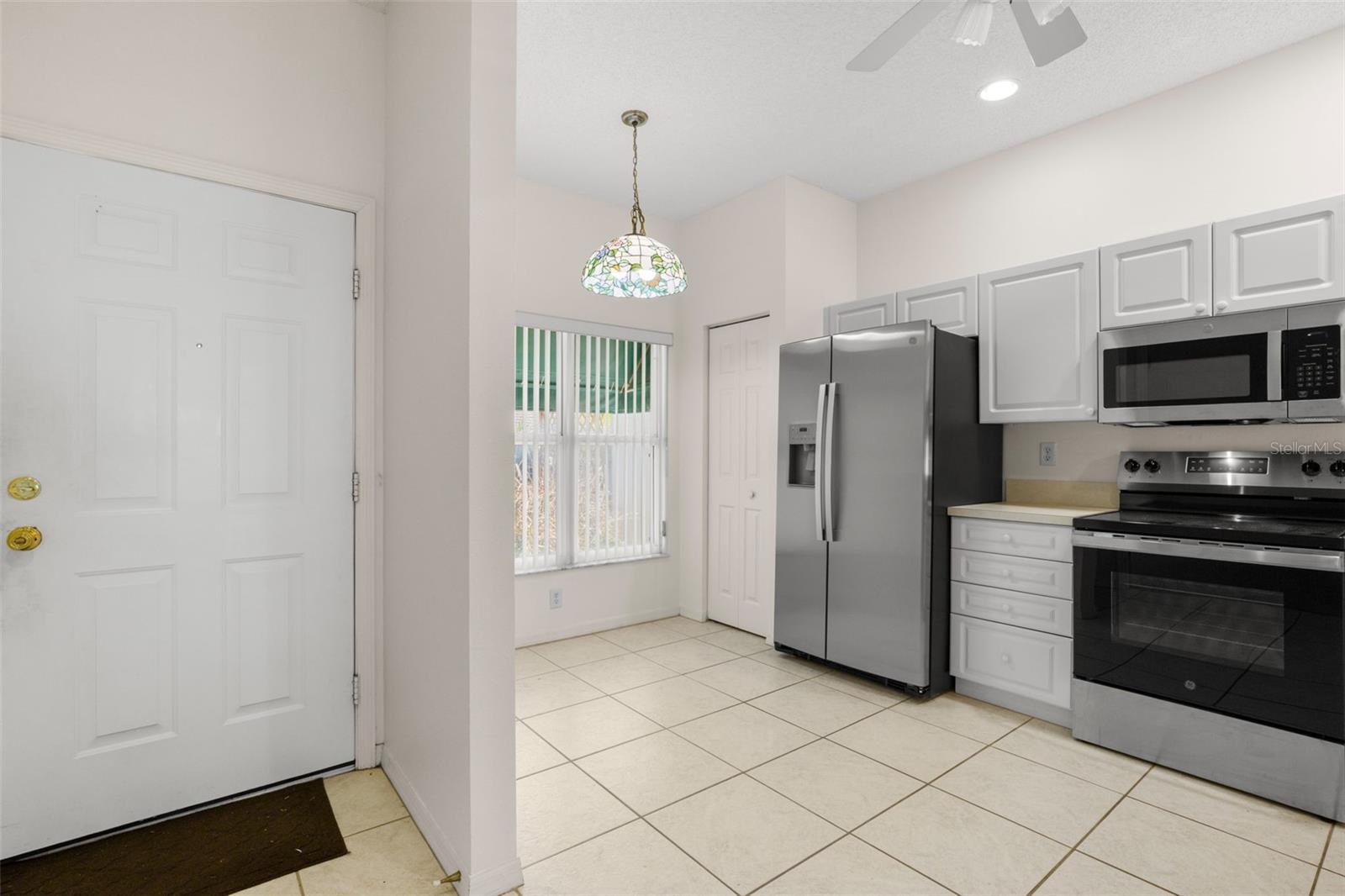 Entry way with kitchen to the left. The kitchen features a ceiling fan with light kit, stainless steel appliances and a breakfast nook. Entry way with kitchen to the left. The kitchen features a ceiling fan with light kit, stainless steel appliances and a breakfast nook.