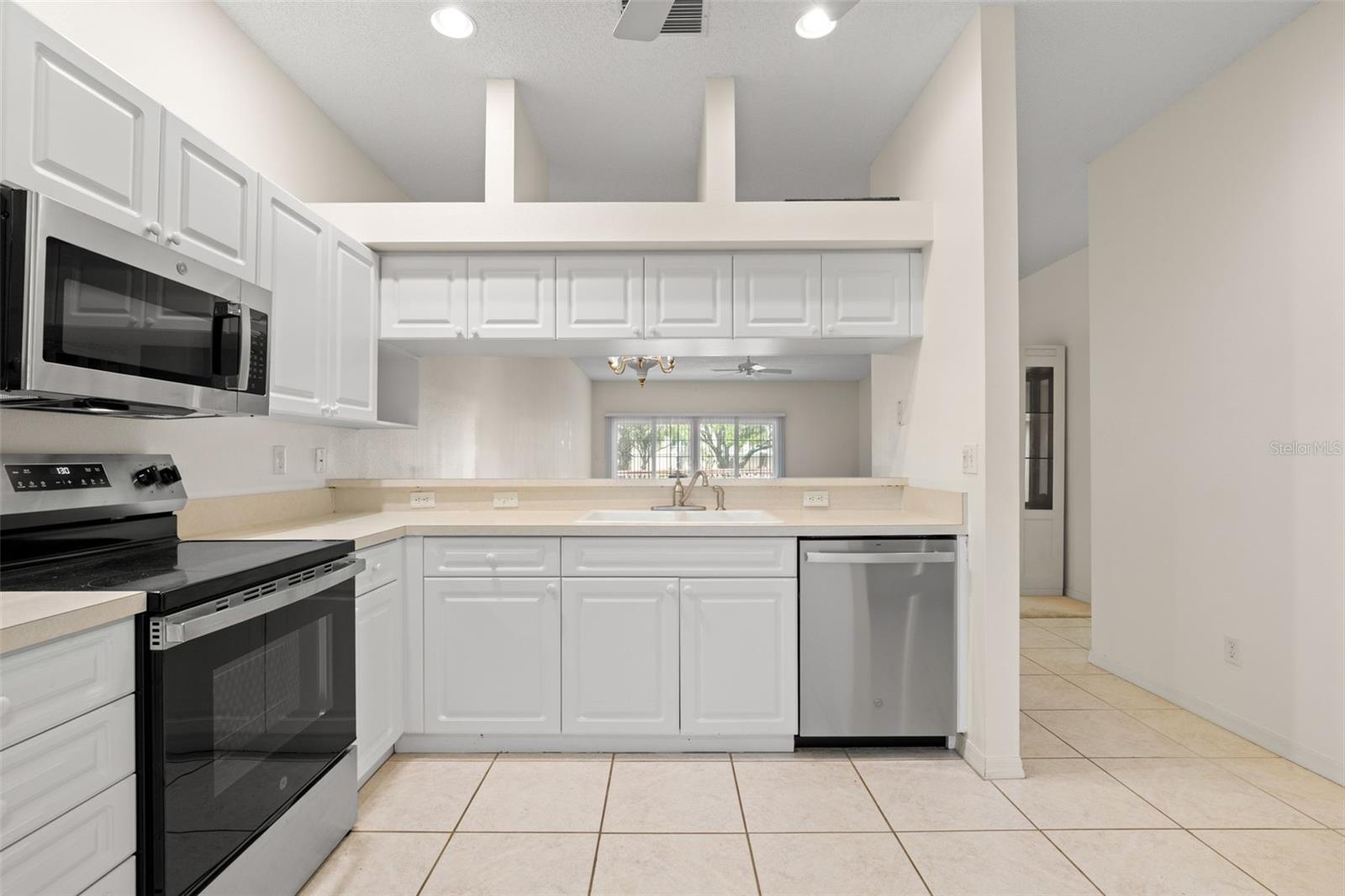 Functional kitchen with extended breakfast bar and pass-through to the living room, creating an open connection the to main living area. Functional kitchen with extended breakfast bar and pass-through to the living room, creating an open connection the to main living area.