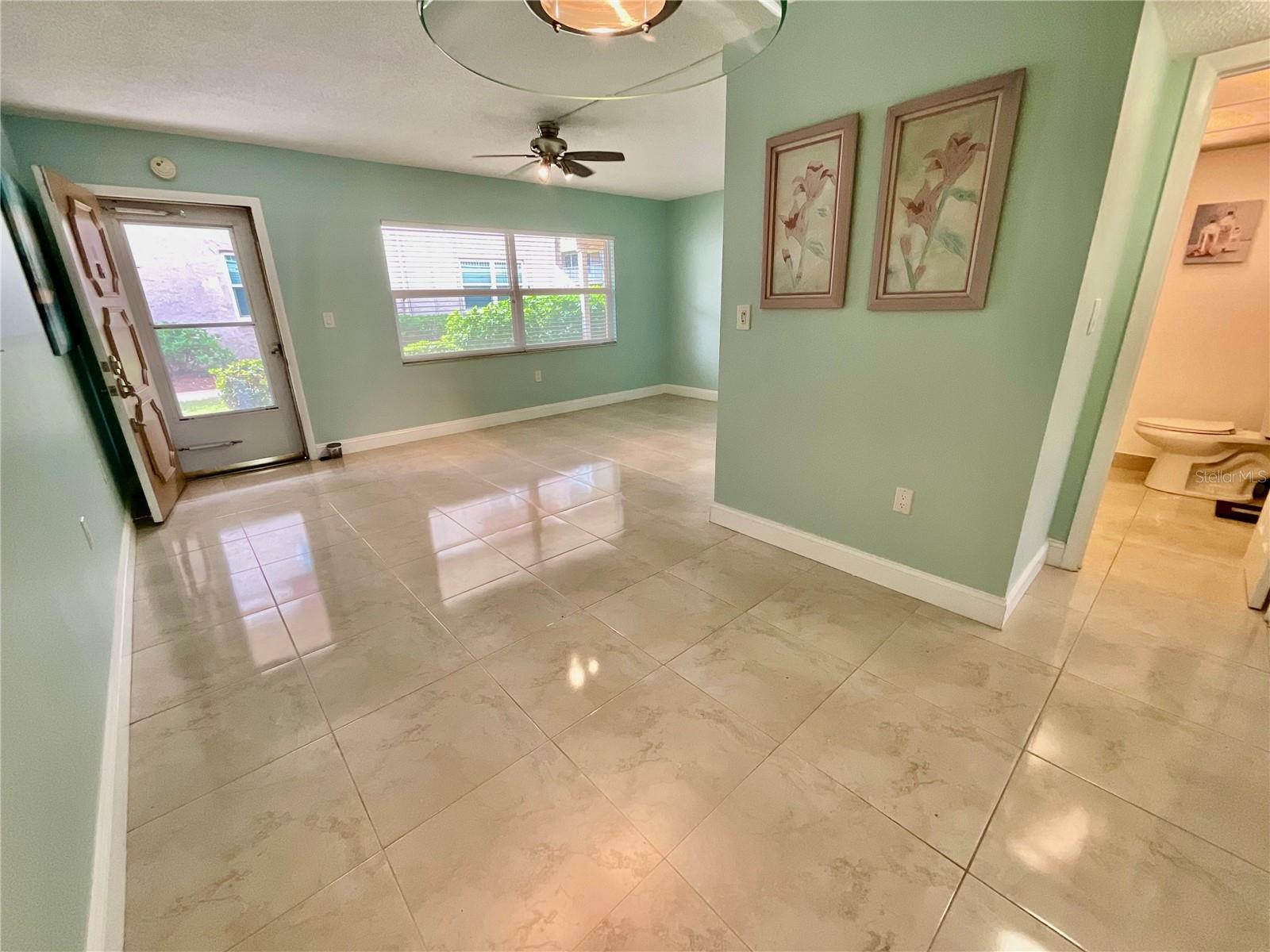 Living/Dining room with door to greenspace and covered, reserved parking spot Living/Dining room with door to greenspace and covered, reserved parking spot