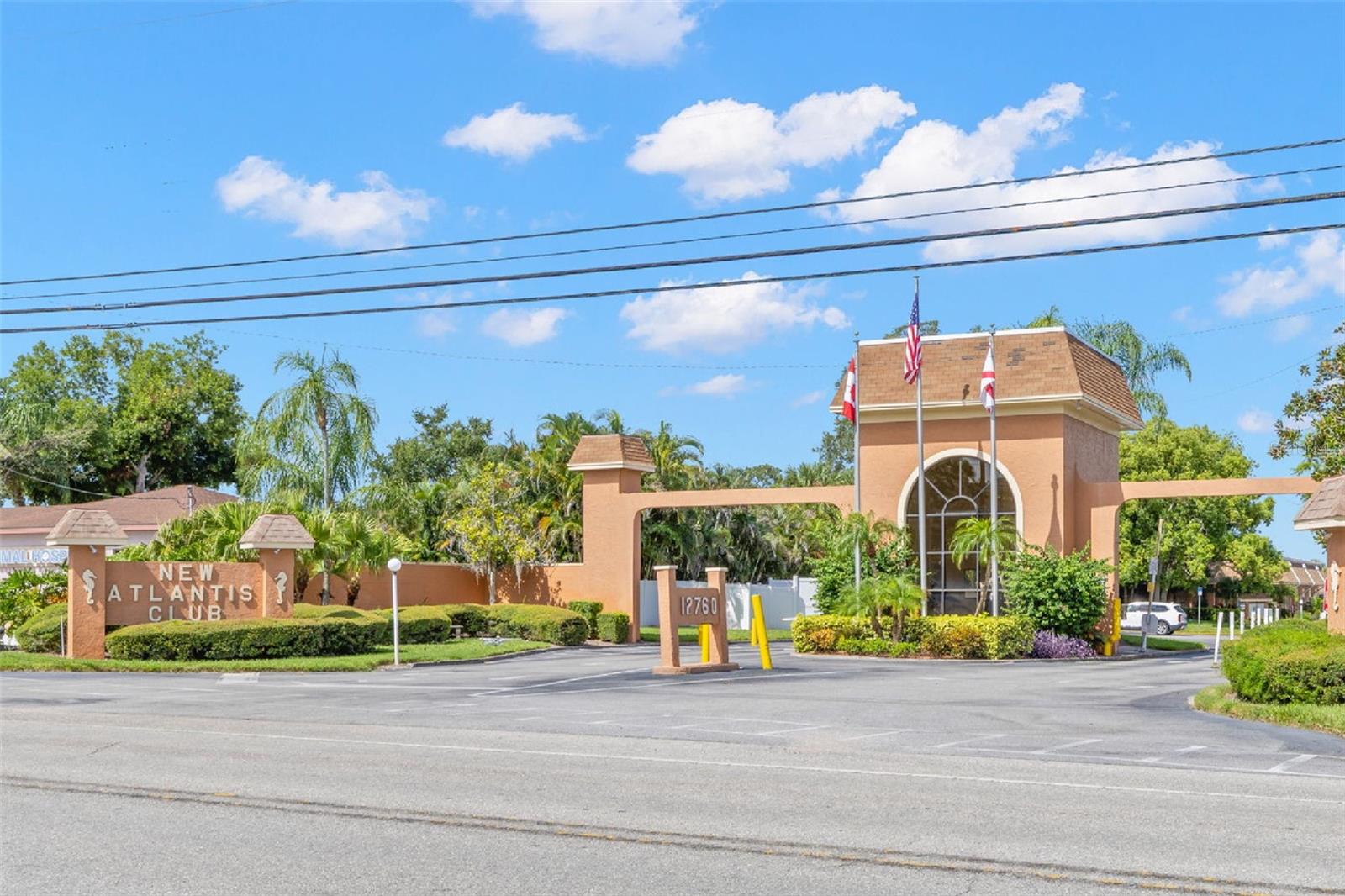 The landscaped entrance to New Atlantis Club creates a defined arrival, with a gated entry, tropical plantings and the communitys signature architectural details setting the tone from the start.