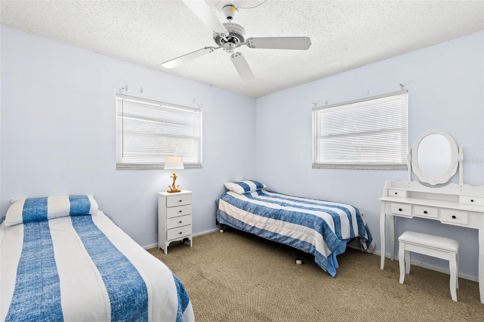 Bedroom 2 measures approximately 10'5" x 11'3", with neutral carpet, a ceiling fan and windows on two walls bringing in plenty of natural light.