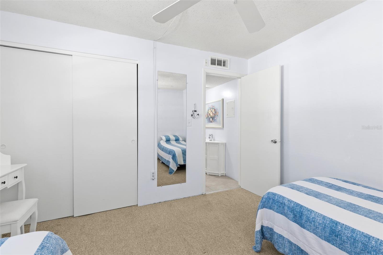 Bedroom 2 includes a built-in closet with sliding doors, neutral carpet and convenient access to the hall and nearby bath.