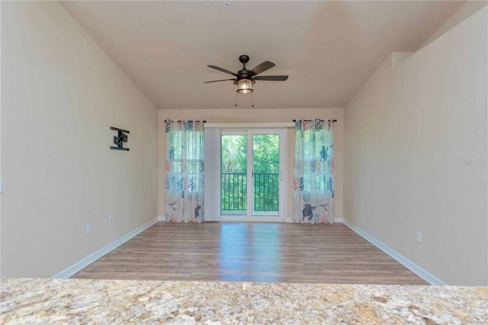 French doors leading to the covered balcony with view of trees.
