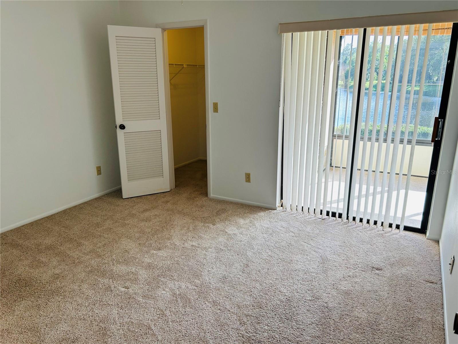 Second bedroom with walk in closet and sliders out to the screened in patio