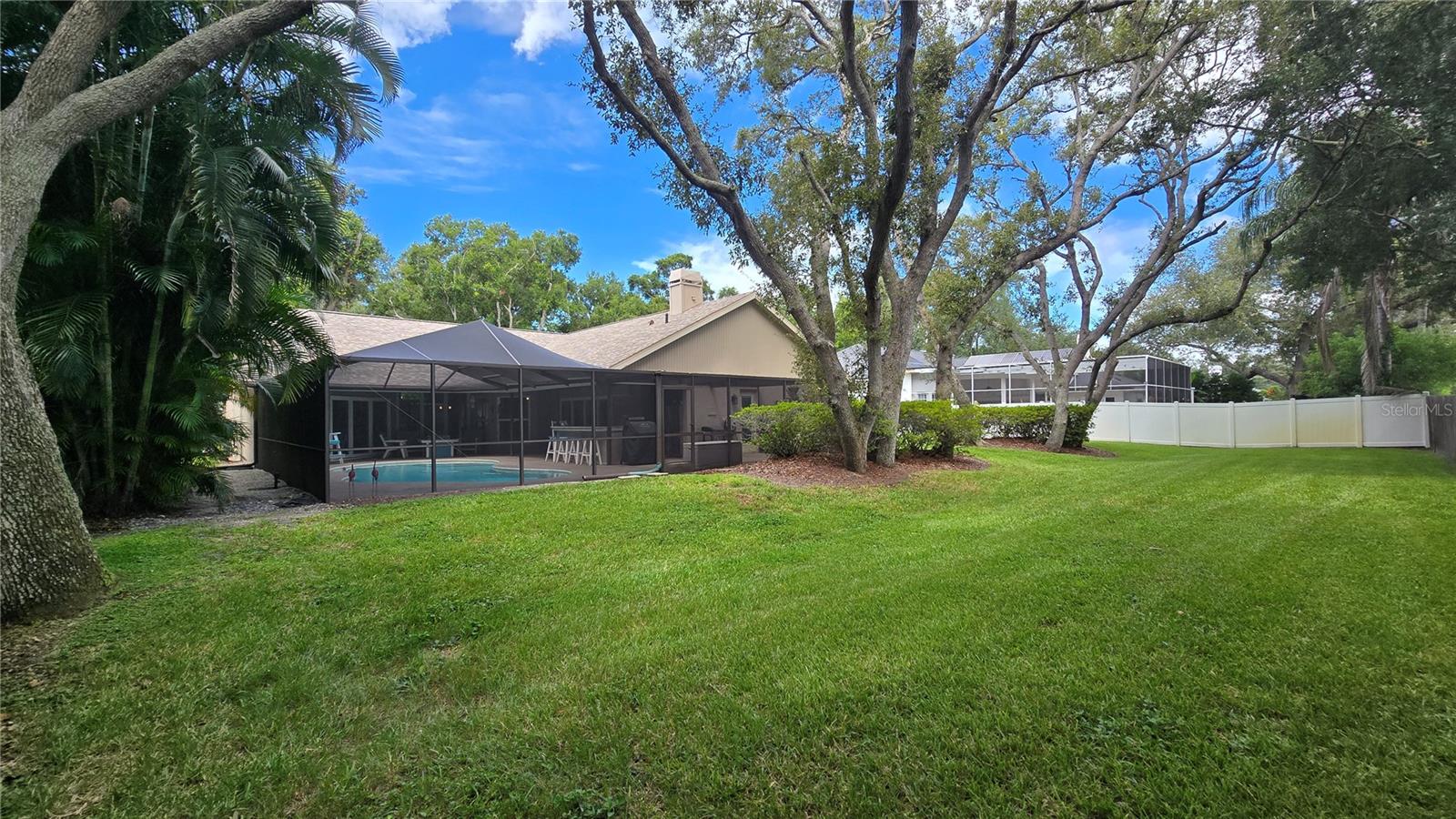 View of the pool area and the back yard. View of the pool area and the back yard.