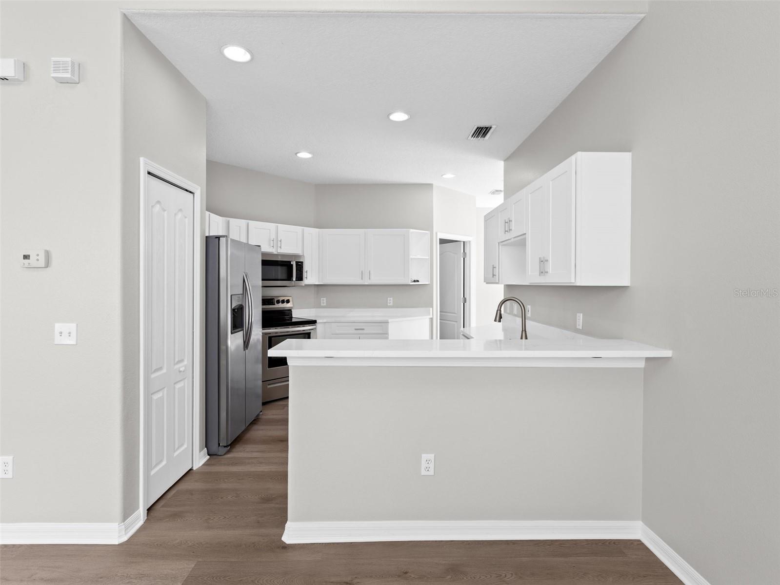 Kitchen with breakfast bar open to living room and dining room