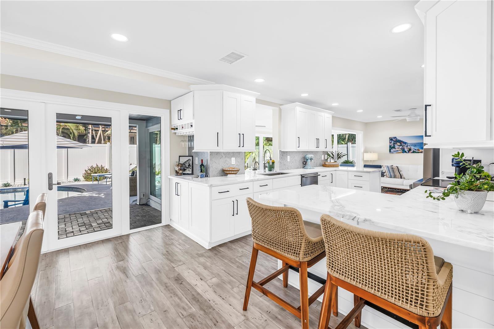 Casual seating to "help" the cook in this Showstopper Kitchen! Quartz countertops have a very light blue hue!