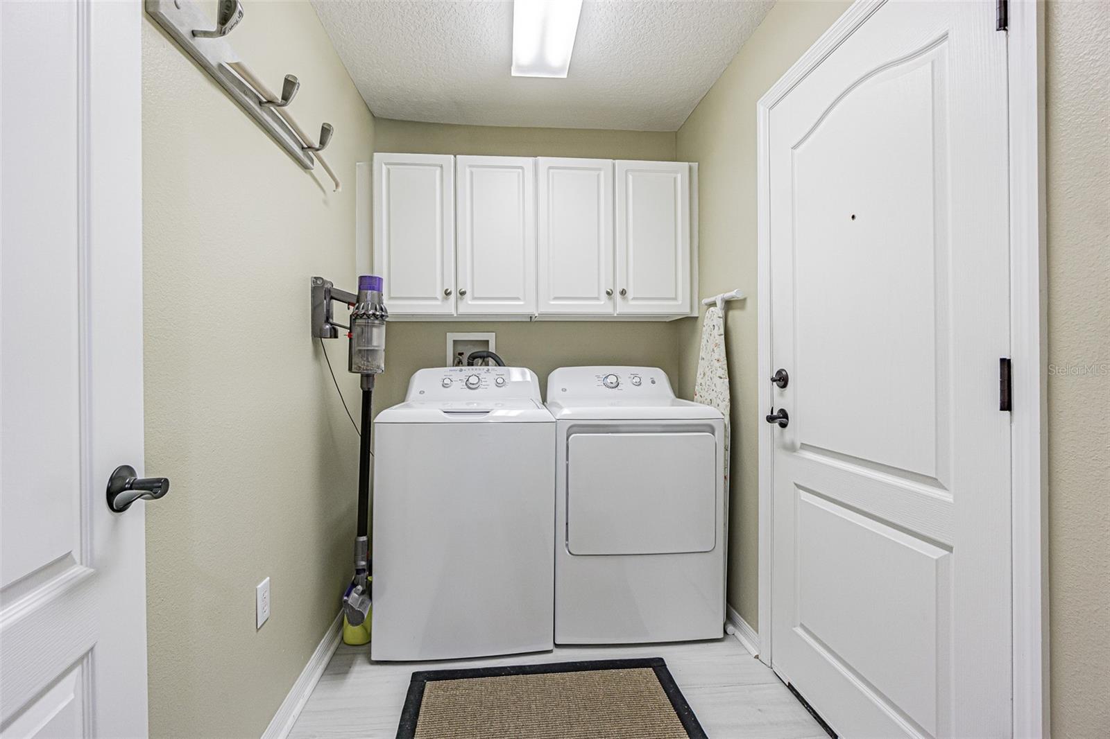 Interior laundry room with storage cabinets above